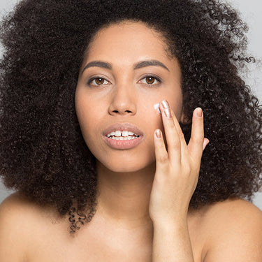 Model applying a cream to her face.