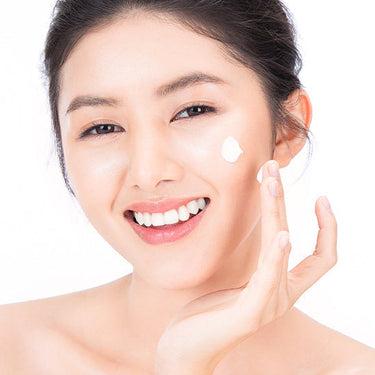 Image of a female model placing Antu Brightening Night Cream on her cheek.