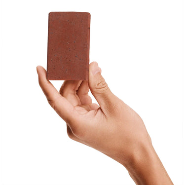 Image of a model holding a bar of Antü Restoring Soap